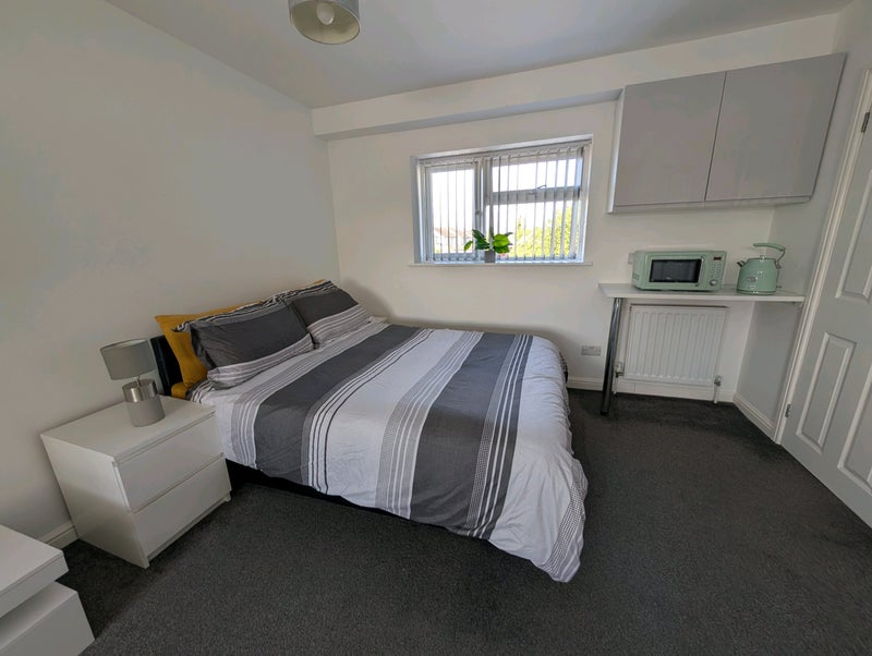 Photo 1: Double bed, microwave, and kettle