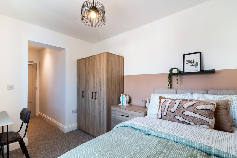 Photo 1: A super ensuite room with a large chest of drawers near entrance to room (not shown in the picture)
