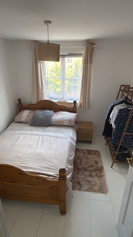 Photo 1: Room includes bed, bedside drawer, clothing rail with storage and small desk with chair