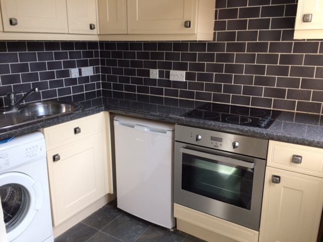 Photo 1: Kitchen with washing m/c, new fridge, tiled.
