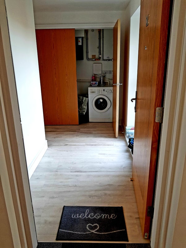 Photo 1: Front door, looking at utility cupboard.