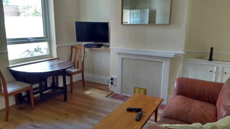 Photo 1: Shared sitting room with sofas, TV, dining table and chairs