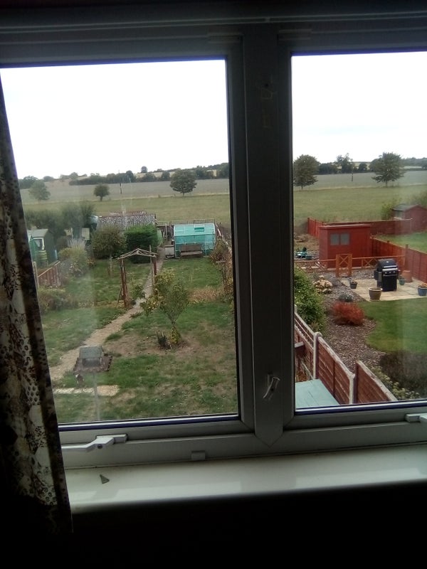 Photo 1: View over farmland from a bedroom window