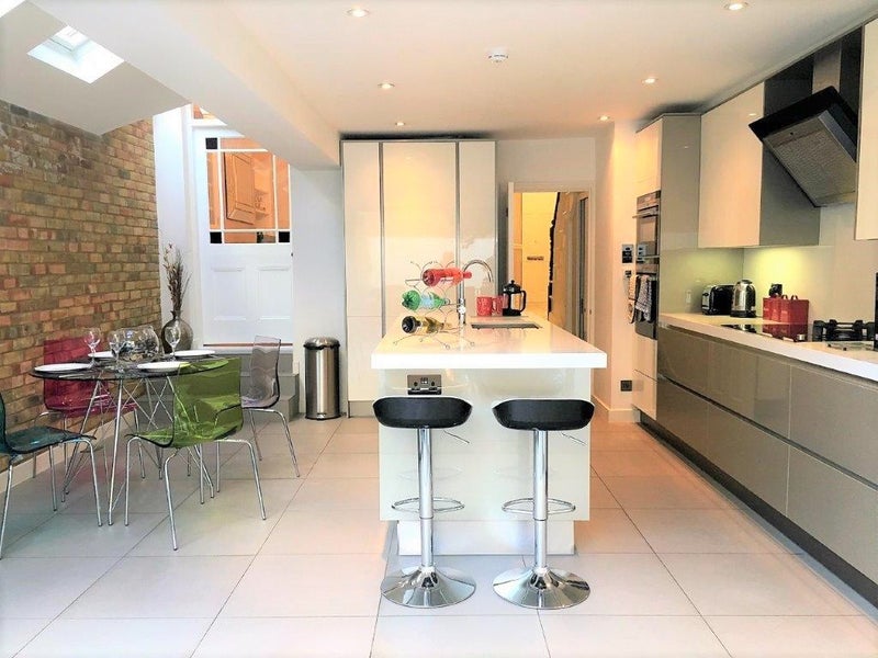 Photo 1: Modern and spacious kitchen with breakfast bar stools