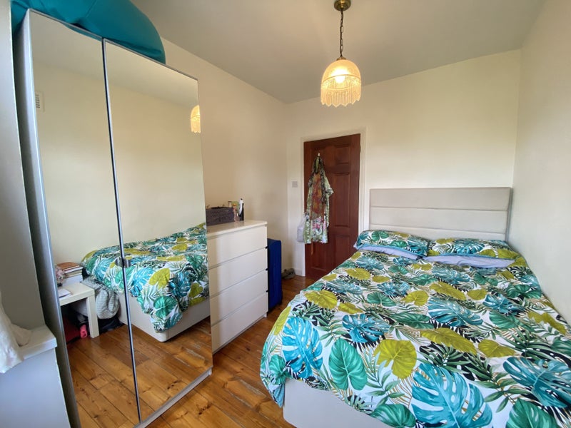 Photo 1: One side of the room showcasing the bed, chest of drawers and a wardrobe.