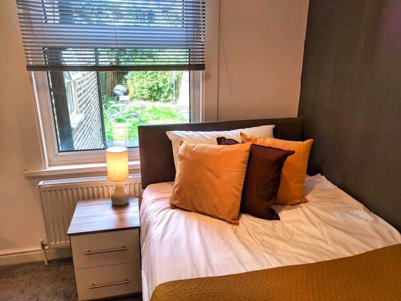 Photo 1: double bed with extra storage underneath with view over the back garden