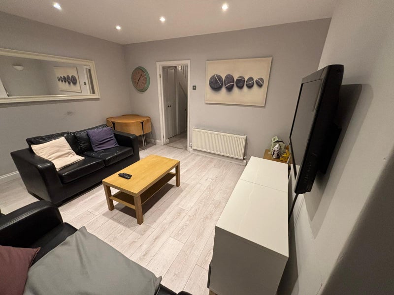 Photo 1: Large lounge with wall TV and diner.