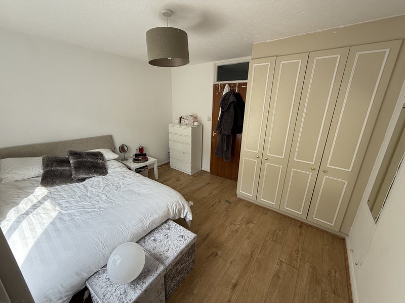 Photo 1: One side of the room showing the bed, bedside, chest and wardrobe