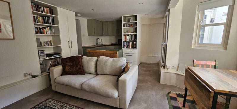 Photo 1: Looking across the sofabed to the kitchen area. The entrance door is on the right and just visible t