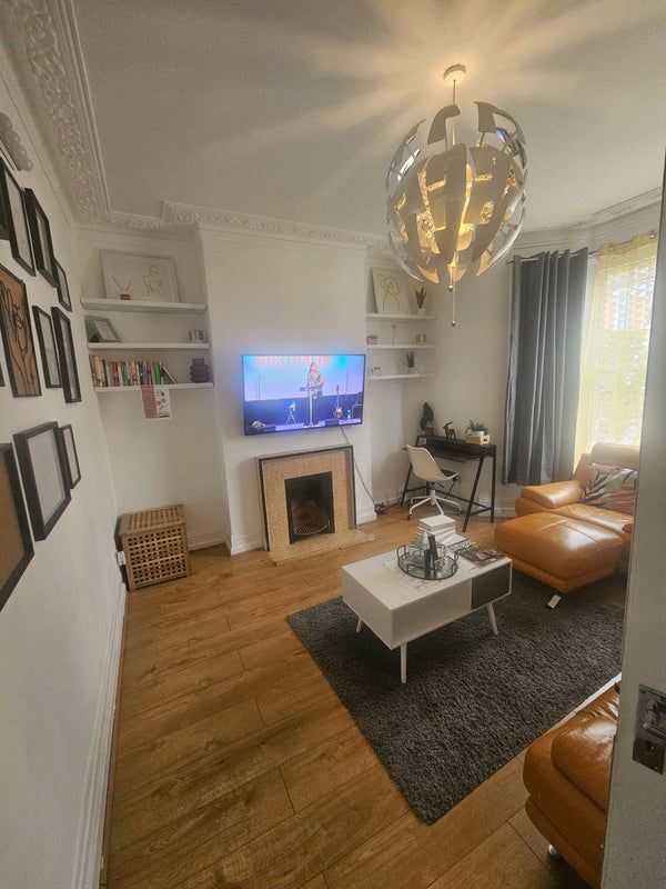 Photo 1: Shared living room with smart TV and desk.