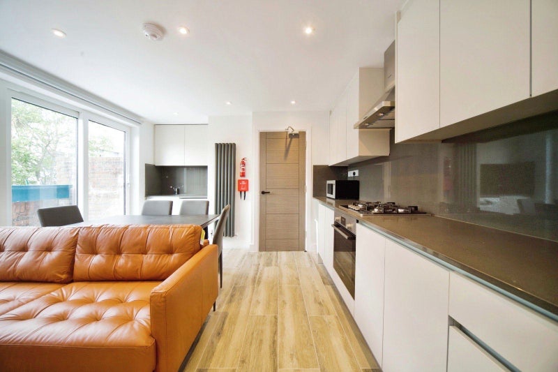 Photo 1: Shared kitchen and living area with balcony access