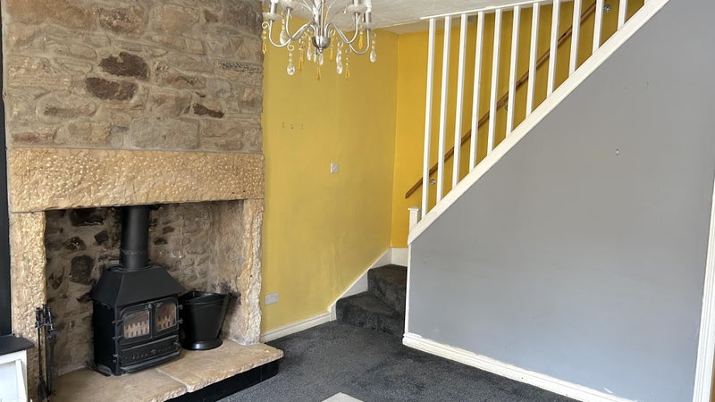 Photo 1: Living room includes wood burner and armchair