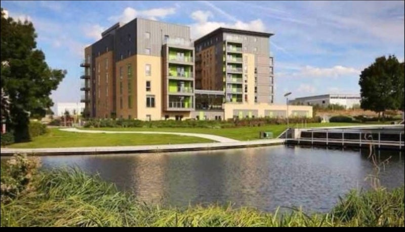 Photo 1: Building surrounded by beautiful lake and park area