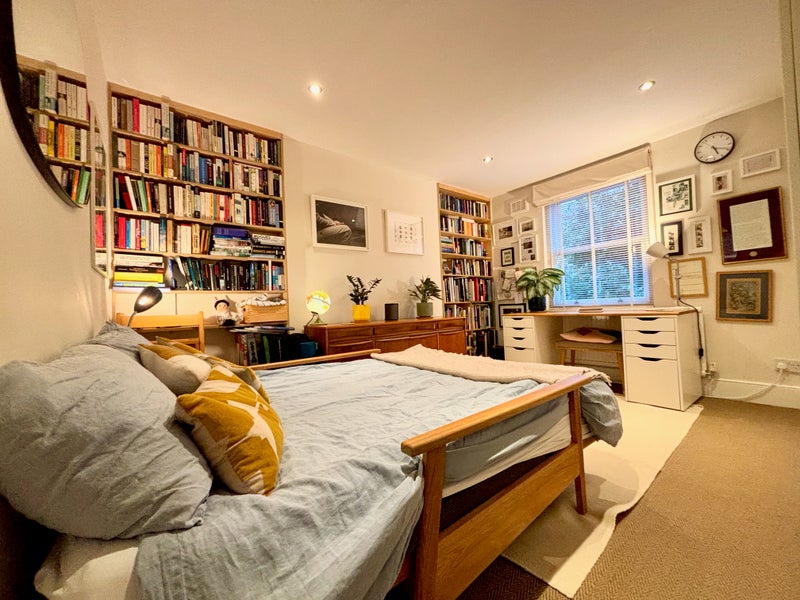 Photo 1: The bedroom as you walk in, filled with books and art