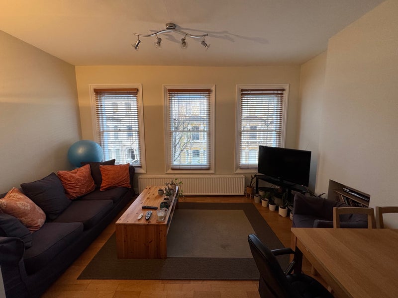 Photo 1: Spacious, bright open-plan living room leading down to kitchen.