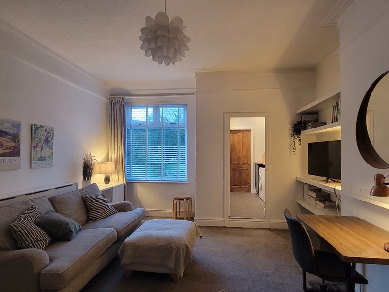 Photo 1: Living area with TV, desk and storage 