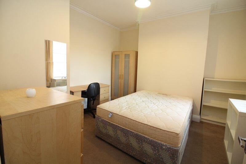 Photo 1: The bedroom is currently rearranged to create more space, with the bed in the corner. 