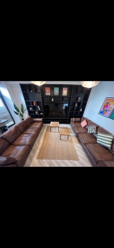 Photo 1: Spacious living room with a comfy sofa and a big TV - perfect for relaxing and social gatherings.