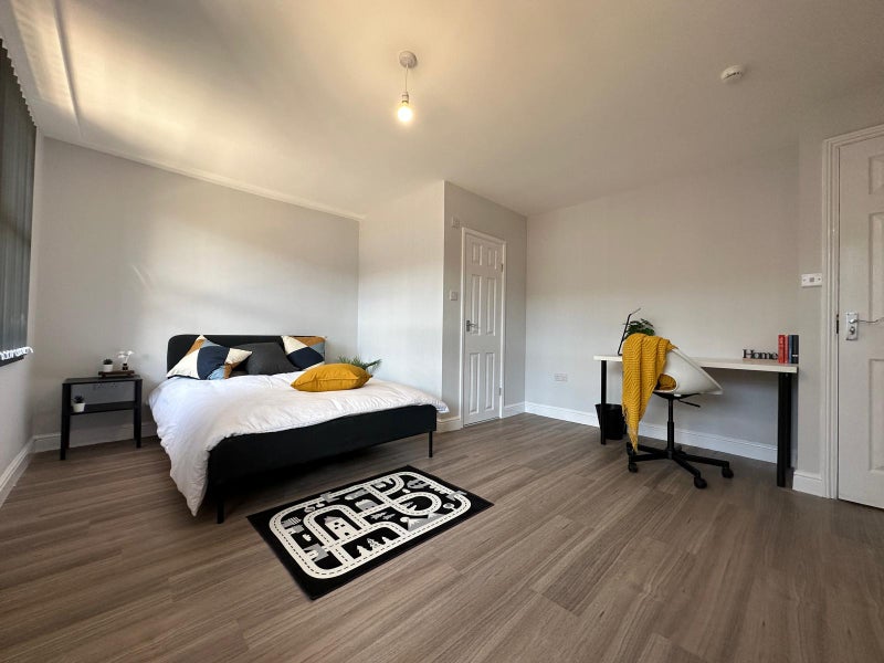 Photo 1: Room comes with double bed, side table, desk, chair, and large standing wardrobe