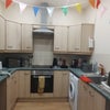Photo 2: Furnished kitchen with washing machine.