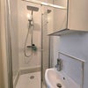 Photo 3: The en-suite includes a cubicle shower with rainflow showerhead, mirrored cupboard, sink and toilet.