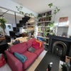 Photo 4: Living room with couches, TV, bookshelf, and desk space under the stairs
