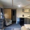 Photo 4: kitchen area of cabin with door to washroom
