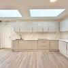 Photo 8: Bright communal kitchen featuring skylights and ample preparation space.