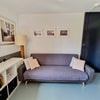 Photo 3: Living space with art prints and a sofa bed.