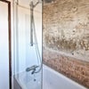 Photo 8: Bath with exposed feature wall behind glazed screen.