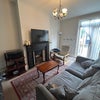 Photo 3: A proper big lounge with two huge sofas, a coffee table, and a massive TV. 