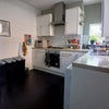 Photo 2: Stone top kitchen, gloss white cupbaords, slate floor