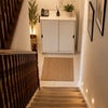 Photo 3: Cozy Staircase Landing with Console and Plants