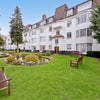 Photo 7:     Main building / pond — Stunning communal gardens with lawn, seating and peaceful pond