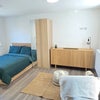 Photo 2: Bright open-plan living and sleeping space with double bed, wardrobe and ample storage.