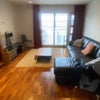 Photo 4: Shared Living room with a huge leather sofa bed , tv and a table.