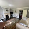 Photo 2: Front room with sofa bed and working wood burning stove