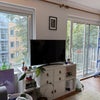 Photo 5: Living room with balcony. There is a table for four just to the right side of the photo.