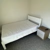 Photo 5: Double bed with plugs and a bed side table right next to it.