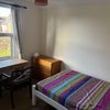 Photo 9: Room has double bed, 2 chests of drawers, hanging closet, long mirror, desk, chair, fireplace