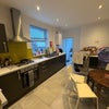 Photo 8: Large kitchen with oven, dining table, fridge freezer, sink, and washing machine in the back