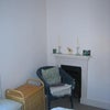 Photo 4: Chair and fireplace in room