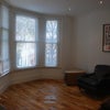 Photo 2: Living Room, now has T.V and Table.