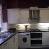 Photo 2: Kitchen area with a table at opposite end