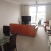 Photo 2: The living-room with two large leather sofas and large flatscreen TV and glass dining table.