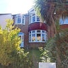Photo 11: The front of the house, with a cute front garden and side access for bikes