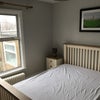 Photo 2: Bedroom is at rear of 2nd floor, side table, lamp, bed mattress & picture, big warm radiator