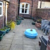 Photo 4: Paved rear yard with seating