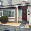 Photo 8: The front of the house, since repainted in cream, with the large, light study room on the left