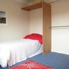 Photo 2: West side of room showing bed alcove and built -in clothes hanging space. 